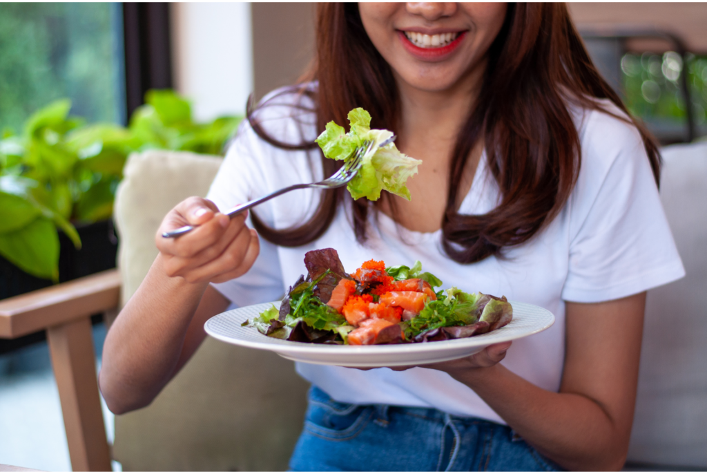 笑顔で野菜を食べる女性