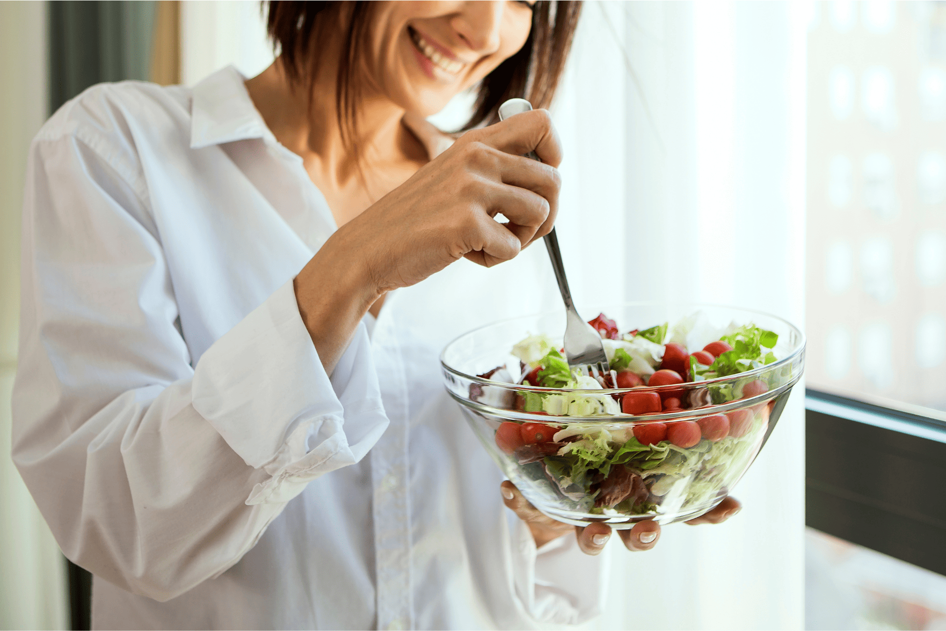 サラダを笑顔を食べる女性