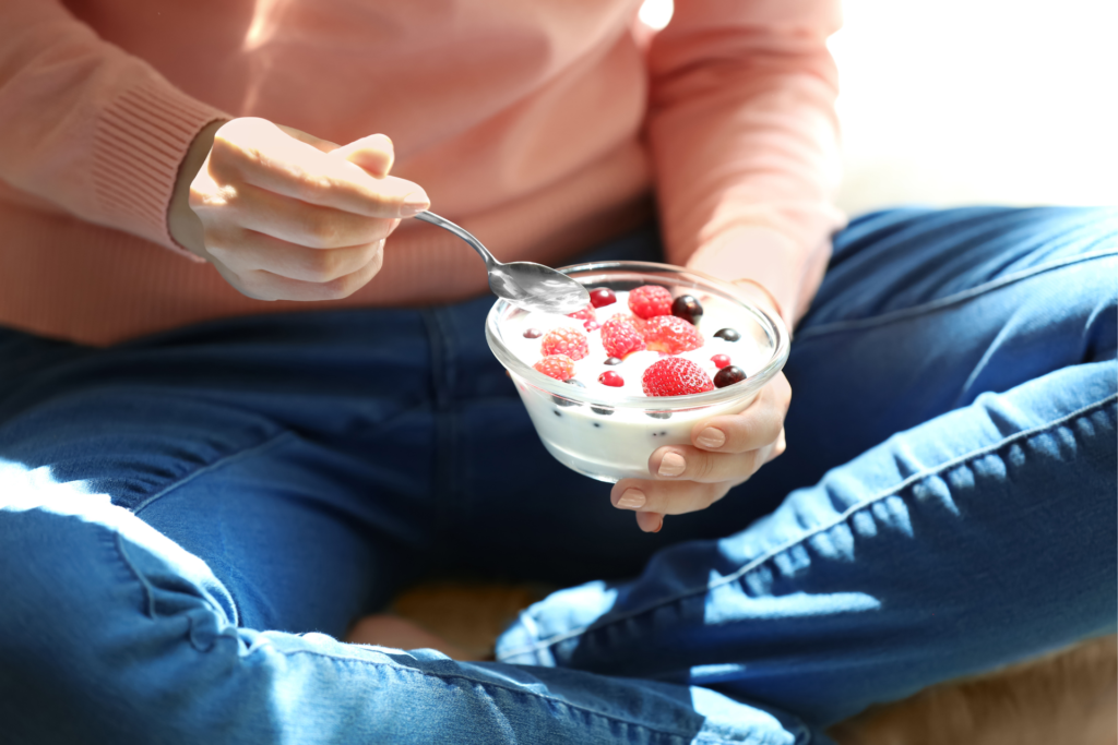 ベリーの乗ったヨーグルトを食べる人